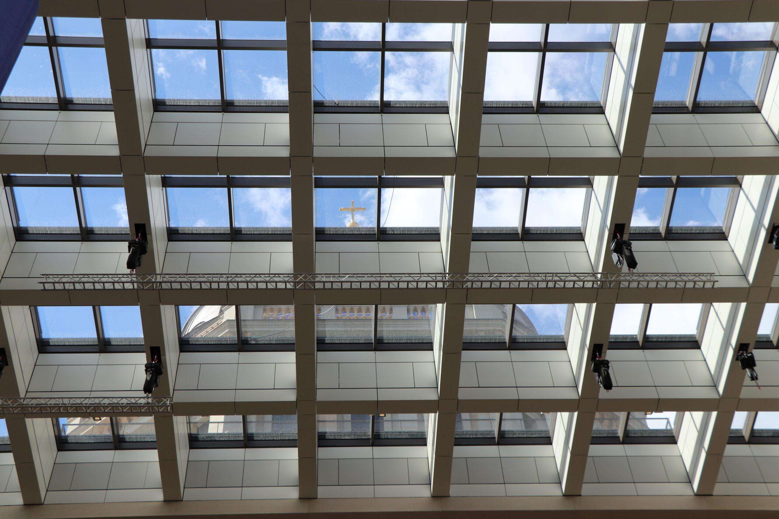 Blickvon unten durch die Deckenkonstruktion im Humboldt Forum; durch die Glasscheiben ist die Kuppel des Gebäudes zu sehen
